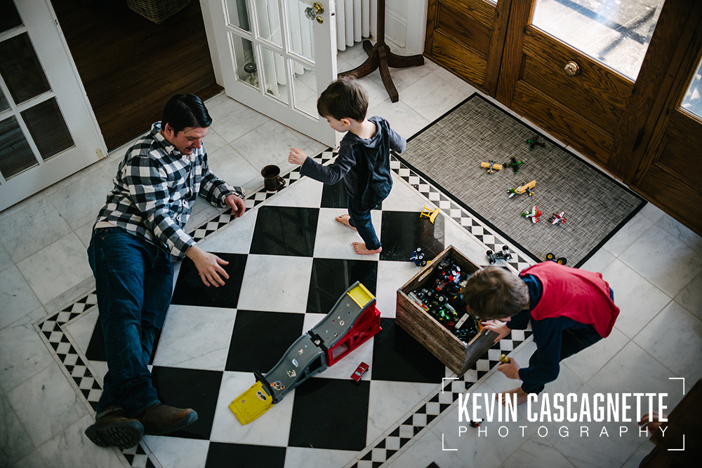 sons-playing-with-dad-on-black-and-white-tile-floor